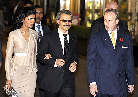 Saudi Prince Alwaleed Bin Talal Bin Abdul Aziz Alsaud (C) walks with his wife Princess Amira (L).