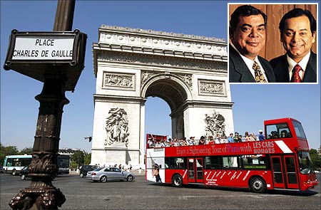 Visitors ride an open-air tourist bus which passes in front of the Arc de Triomphe, near the Champs Elysees in Paris. Shashi and Ravi Ruia (inset).