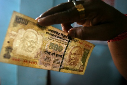 An employee checks a 500 Indian rupee note at a cash counter inside a bank in Agartala.