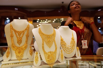 A saleswoman displays a gold necklace at a jewellery showroom in Kolkata.