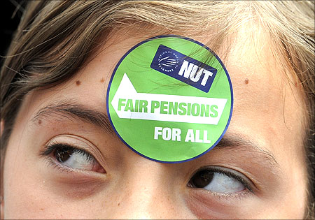 Ava Cowperthwaite aged 11 watches during  a protest over pension reforms in Leeds, northern England.