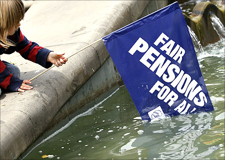 A boy plays with a banner in a fountain during a protest over pension reforms in Birmingham, central England.