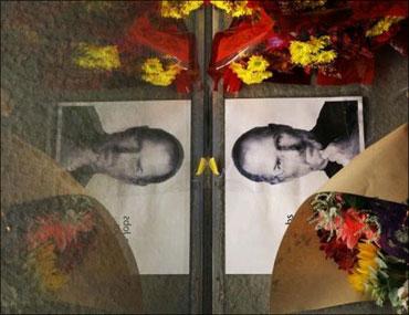 Flowers and a photograph of Steve Jobs are placed against the window outside the Apple store in Boston, Massachusetts.