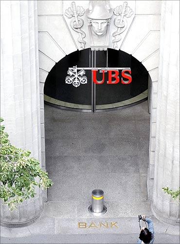 A woman takes a picture in front of the branch office of Swiss bank UBS at the Bahnhofstrasse in Zurich.