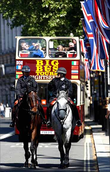 Mounted police officers ride ahead of a tour bus in Westminster.