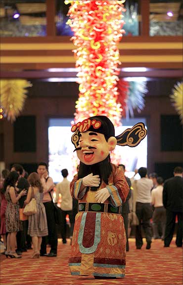A man dressed as a Chinese God of Fortune walks inside the Resorts World Sentosa casino on Singapore's Sentosa Island.