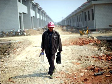 A labourer walks at a construction site.