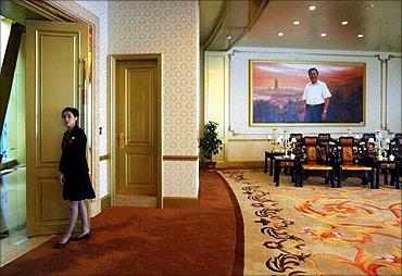 A woman stands at the entrance of a meeting room inside of the new skyscraper tower of Huaxi village.