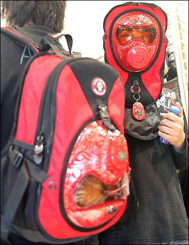 South Koreans demonstrate the use of backpacks with built-in gas masks at a department store in Seoul.