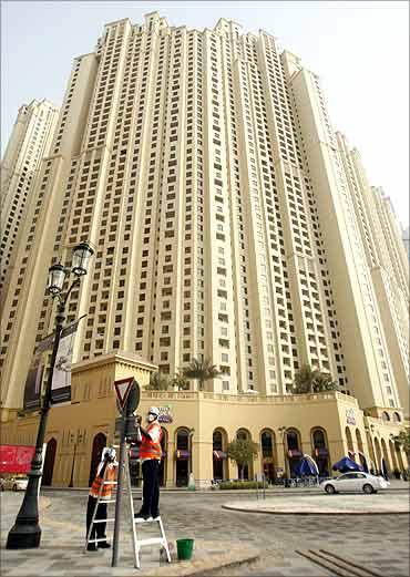 People work on a street sign near residential towers in Jumeirah Beach Residence (JBR).