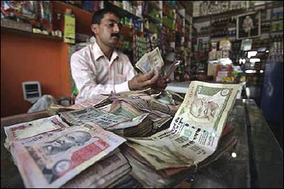 A shopkeeper counts rupee notes inside his shop in Jammu.