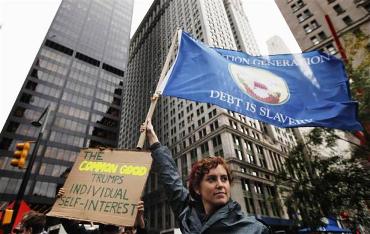 A member of the Occupy Wall Street movement, Ashlie Smith, holds a flag aloft while protesting in Zuccotti Park near the financial district of New York.