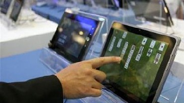 A visitor plays with a tablet PC at the Intel booth during the Computex 2011 computer fair at the TWTC Nangang exhibition hall in Taipei.
