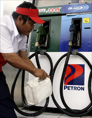 A petrol station employee cleans a fuel pump as he waits for customers in Manila.