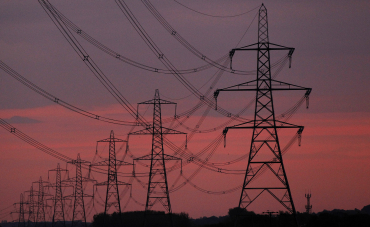 The sun rises behind electricity pylons near Chester, northern England.