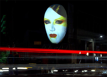 Cars travel past the 'Faces of Berlin' light installation during the Festival of Lights in Berlin.