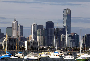 Sailboats and yachts are seen in front of the Melbourne skyline.