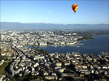 A hot air balloon flies above the city of Geneva.