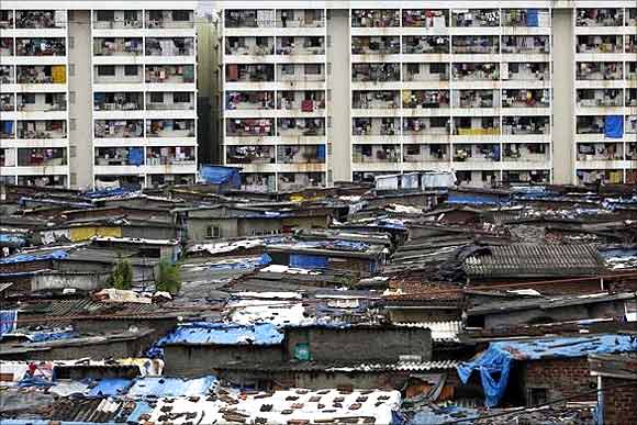 High rise residential buildings are seen behind a slum in Mumbai.