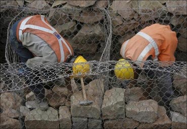 Workers arrange stones.