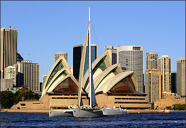 The 34 metre long French-owned trimaran Geronimo crosses in front of the Sydney Opera House.