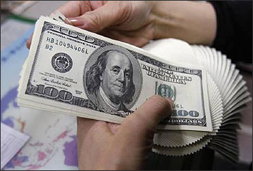 An employee of an money exchange counts US dollar bills in Tokyo.
