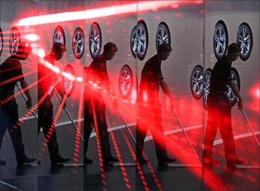 a worker for German car manufacturer Audi is mirrored in a facade during preparation work for the IAA.