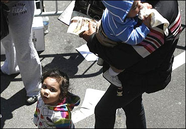 A child waits in line with her mother to receive goods from the Feed The Children relief organisation in New York.