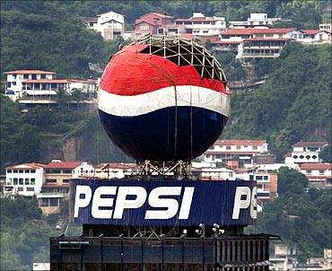 Workers remove panels from a Pepsi ball advertisement in Caracas.