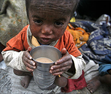 Three-year-old Babu, a child of a migrant labourer outside a makeshift tent along a road on a cold morning.