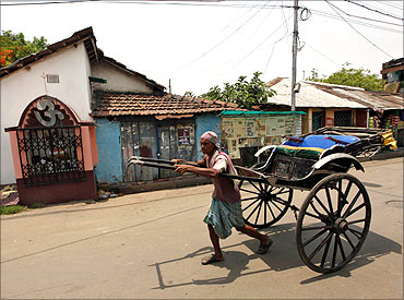 A handcart puller walks past the house of Railways Minister and Trinamool Congress (TMC) chief Mamata Banerjee in Kolkata.