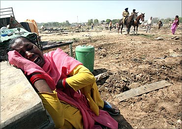 A slum dweller cries after her house was demolished by local authorities at a slum area in Chandigarh.