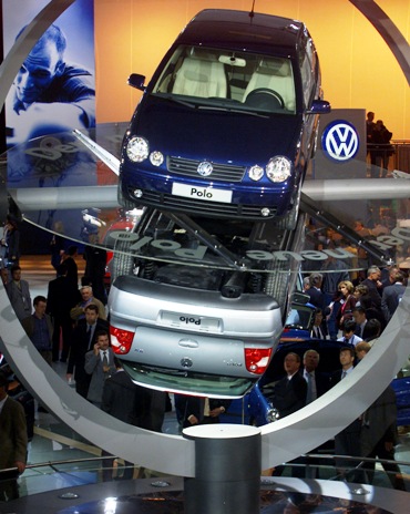 Visitors walk past two Volkswagen Polo cars at the 59th Frankfurt car show.