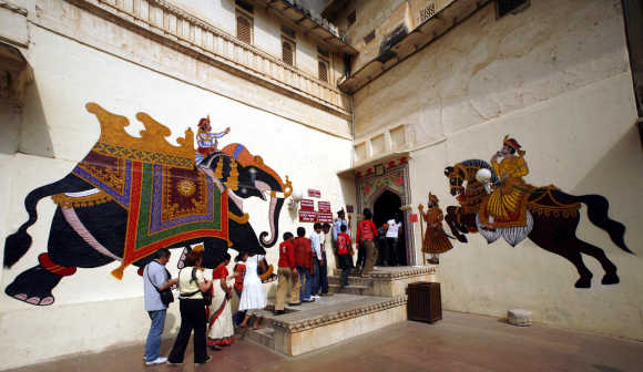 Tourists stand in a queue outside the entrance of the City Palace in Udaipur, Rajasthan.
