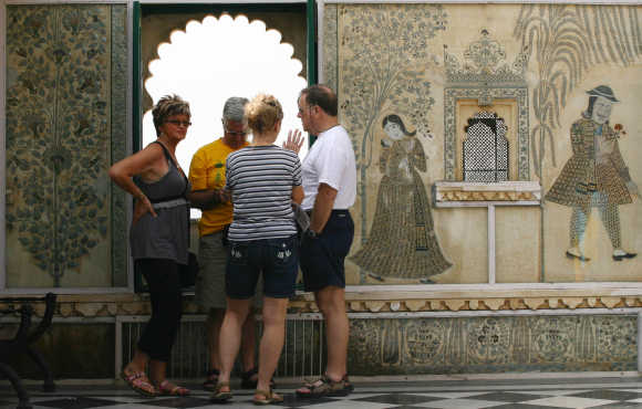 Tourists stand at the City Palace in Udaipur, Rajasthan.