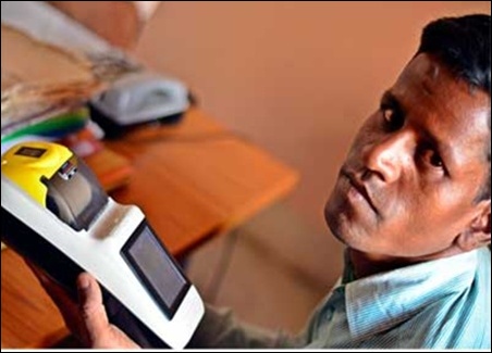 Rajesh Kumar, a former science teacher and currently the banking correspondent of Ramgarh's Dohakatu village, shows off his Micro ATM, which is used to make Aadhaar-enabled MNREGA payments.