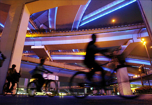 Cyclists pedal under the colourful Yanan elevated highway in Shanghai.