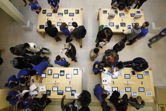 Customers look at Apple's new iPad 4G-ready tablet computer at one of their stores in Paris.