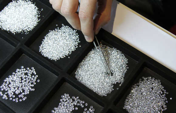 A vendor inspects 0.20 carat diamonds during the 3rd Antwerp Diamond Trade Fair in Antwerp.