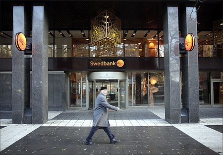 A man walks past the Swedbank head office in Stockholm.