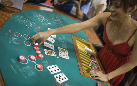 A female croupier places casino chips during the Global Gaming Expo Asia in Macau.