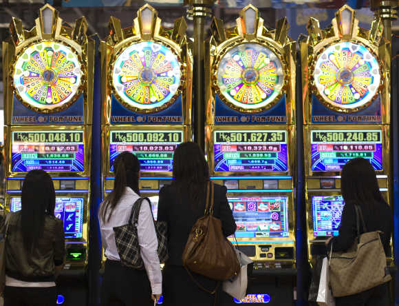 Women play slot machines during the Global Gaming Expo Asia at the Venetian Macao-Resort-Hotel in Macau.
