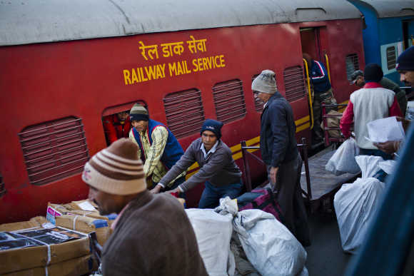 Workers load mail onto a train at Nizamuddin Railway Station.