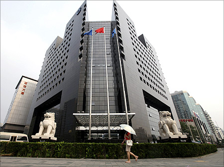 A woman walks in front of the China Construction Bank headquarters building in Beijing.