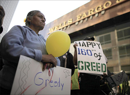 Elena Ruiz, 50 holds a sign during a march outside Wells Fargo to protest foreclosures in Los Angeles, California.