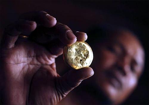 A local gold trader shows a piece of gold after he purchased it from a gold miner at the mine site in Poboya in Indonesia, Central Sulawesi province.