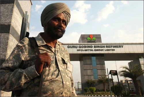 A security personnel stands guard in front of the main entrance of the Guru Gobind Singh oil refinery.