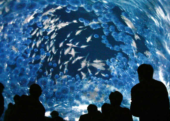 Visitors look at the Earth Room, the world's first 360-degree all-sky image system, in Nagoya.