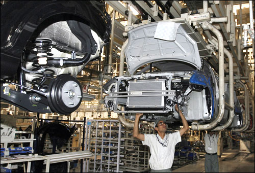 Workers assemble a car at a Maruti Suzuki plant in Manesar.