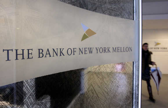 A woman walks past a logo at the office of the Bank of New York Mellon in Brussels.